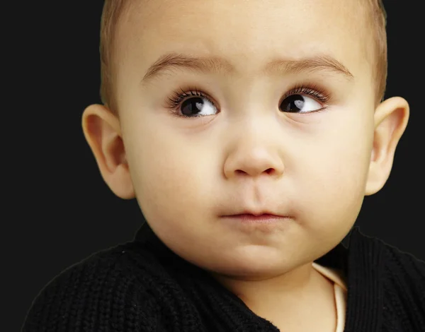 Retrato de bebê adorável olhando para cima sobre fundo preto — Fotografia de Stock