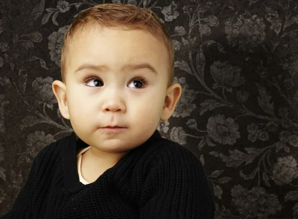 Portret van een schattige baby kijkend tegen een vintage muur — Stockfoto