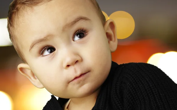 Retrato de bebê adorável olhando para cima contra um abstrato luzes b — Fotografia de Stock
