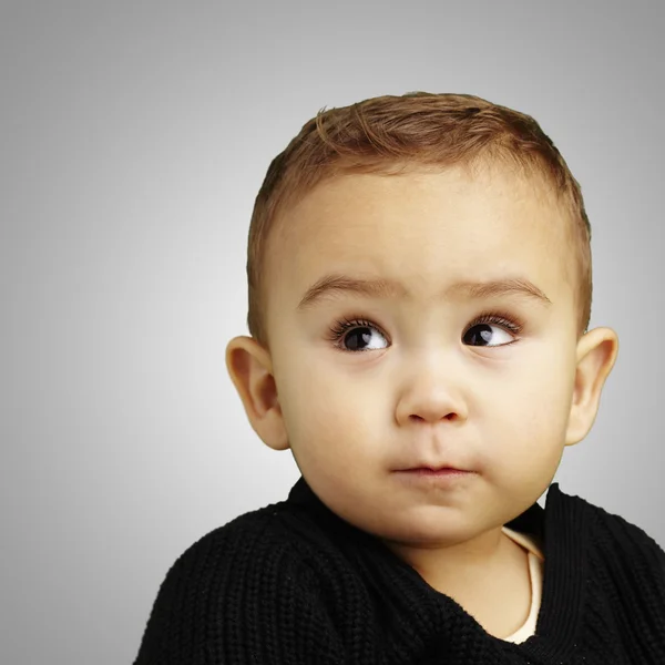 Portræt af sød baby ser op over grå baggrund - Stock-foto