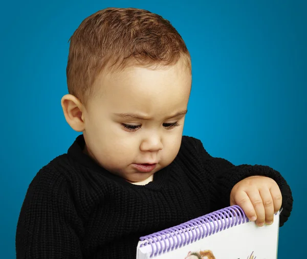 Portret dziecko gospodarstwa Notebook na niebieskim tle — Zdjęcie stockowe