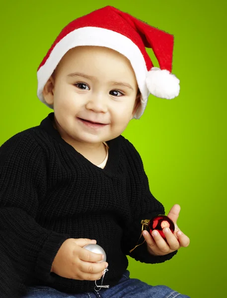 クリスマス ボンネットを身に着けている緑の向こうに喜んでいる子供の肖像画 — ストック写真