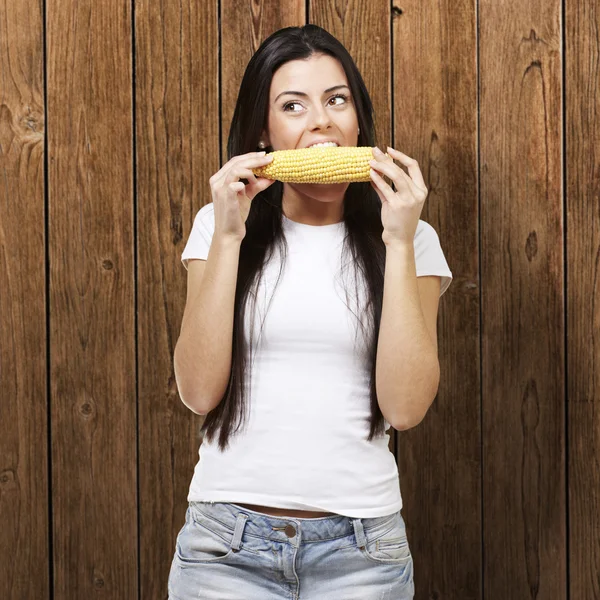 Kadın bir mısır koçanı yiyor — Stok fotoğraf