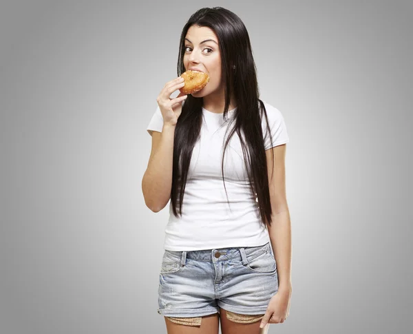 Femme mangeant un beignet — Photo