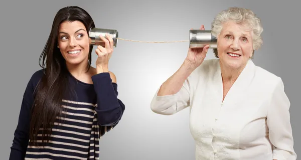Portrait of young girl and her grandmother hearing sounds using — Stock Photo, Image