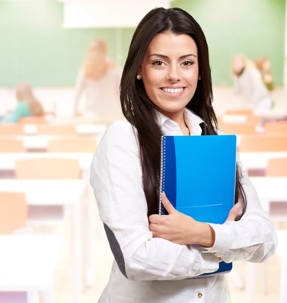 Porträt einer jungen Frau mit Notizbuch im Klassenzimmer — Stockfoto