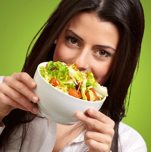 Retrato de jovem segurando uma salada fresca sobre verde — Fotografia de Stock