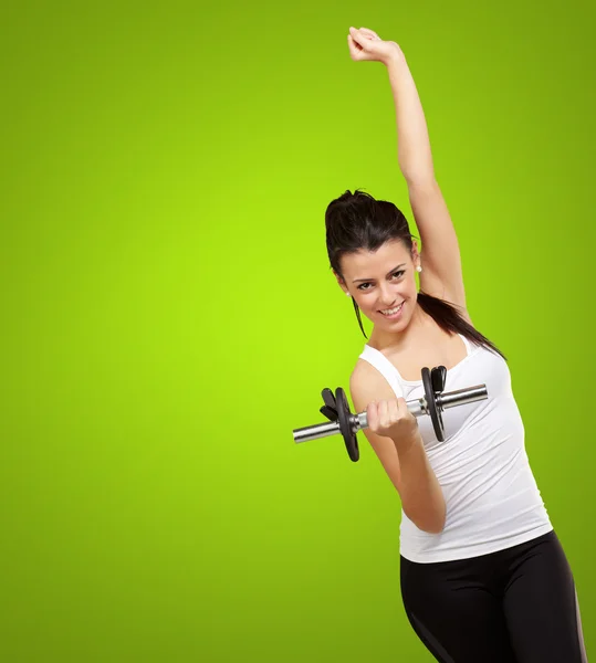 Portrét mladé ženy dělá fitness s hmotností nad zeleným ba — Stock fotografie