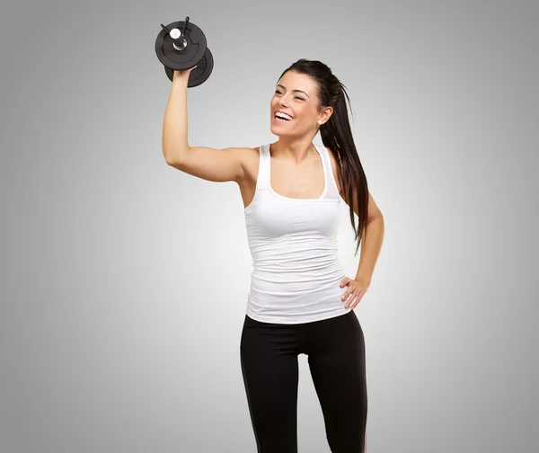 Portrait of young girl training with weights over grey backgroun — Stock Photo, Image