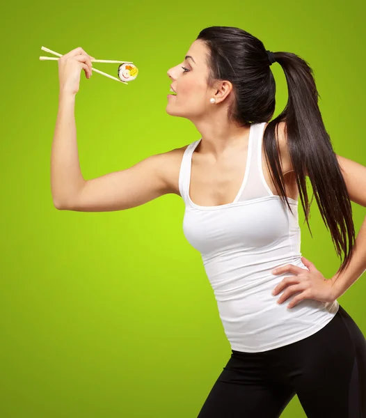 Genç kadın suşi yemek yeşil arka plan üzerinde oldukça — Stok fotoğraf