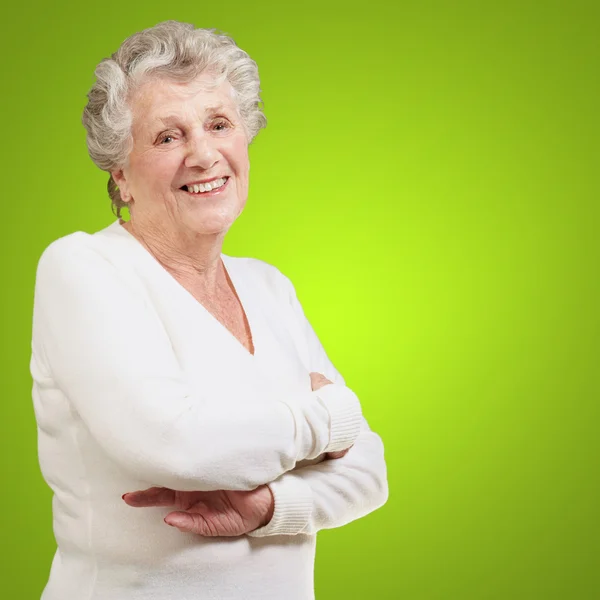 Портрет пожилой женщины, улыбающейся на зеленом фоне — стоковое фото
