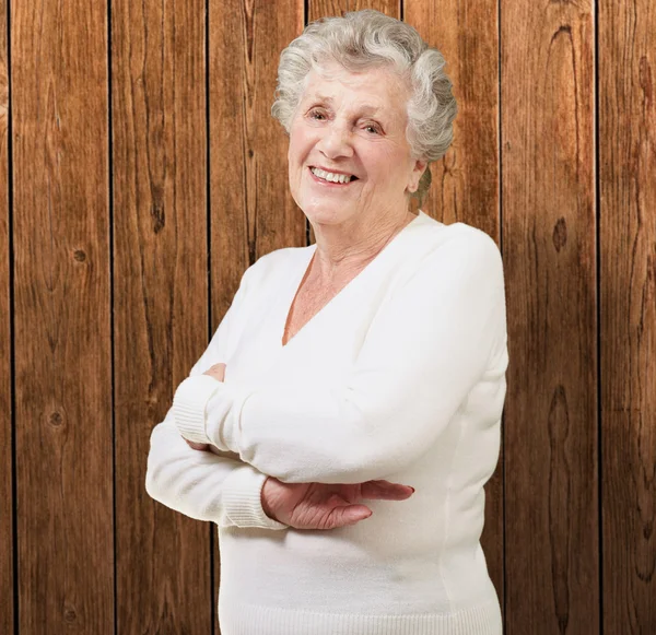 Портрет пожилой женщины, улыбающейся у деревянной стены — стоковое фото