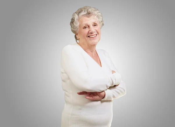 Портрет пожилой женщины, улыбающейся на сером фоне — стоковое фото
