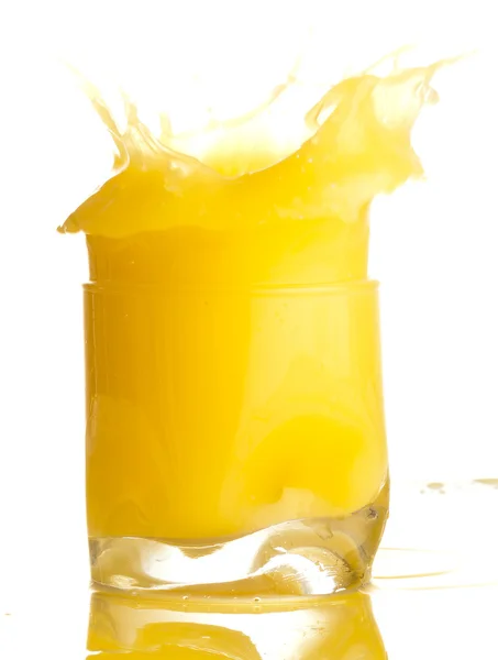 Orangensaft spritzt auf einem Glas auf weißem Hintergrund — Stockfoto