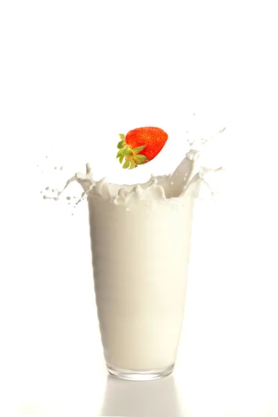 Strawberry falling on milk — Stock Photo, Image