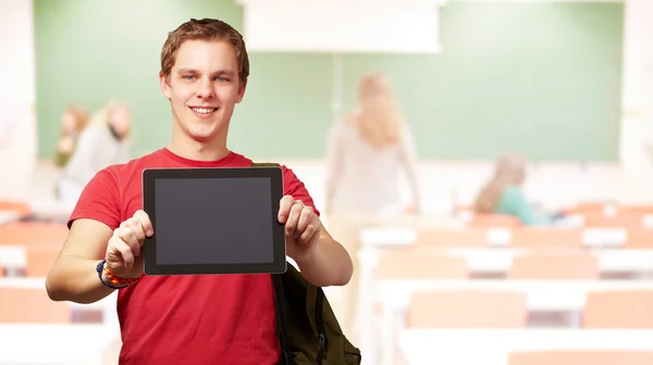 Retrato del joven sosteniendo una tableta digital en el aula Fotos de stock