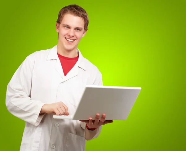 Laptop yeşil arka plan üzerinde tutan genç bir öğrenci portresi Telifsiz Stok Fotoğraflar