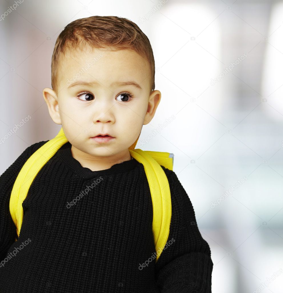 Adorable niño latino weraring una camiseta amarilla aislado sobre un fondo  blanco.
