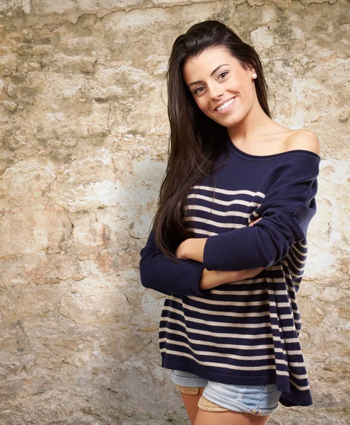 Portrait of young woman smiling against a stone wall — Stock Photo, Image