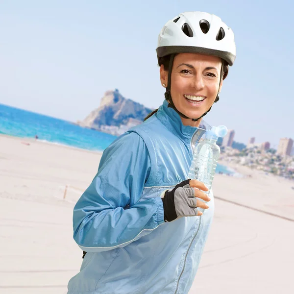 Portrait of cyclist middle aged woman holding a water bottle in — Stock Photo, Image