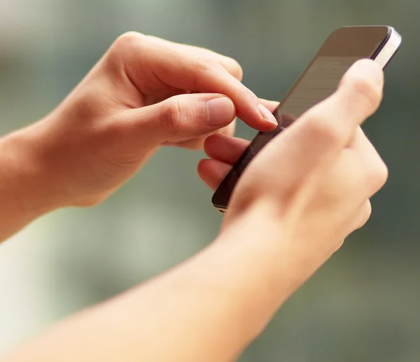 Jovem tocando um celular moderno, close-up — Fotografia de Stock