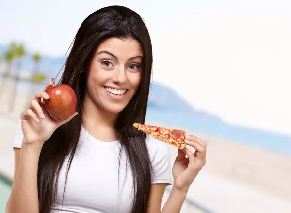 Młoda dziewczyna z jabłkiem i pizza — Zdjęcie stockowe