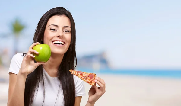 年轻的女孩与一个苹果和一个比萨饼 — 图库照片