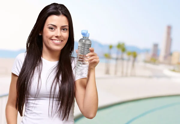 Chica joven que ofrece una botella de agua — Foto de Stock