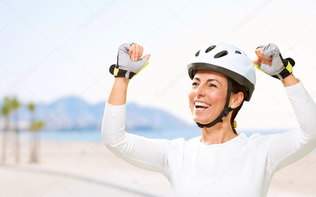 Portrait of a cheerful sporty middle aged woman doing a victory