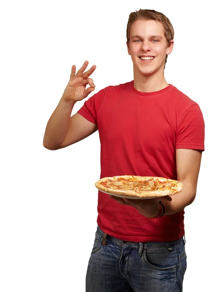 Ritratto di giovane uomo che tiene la pizza e fa buon gesto sopra — Foto Stock