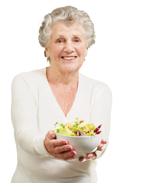 Retrato de mujer mayor mostrando una ensalada fresca sobre fondo blanco — Foto de Stock