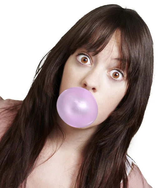 Young girl with a pink bubble of chewing gum against a white bac — Stock Photo, Image