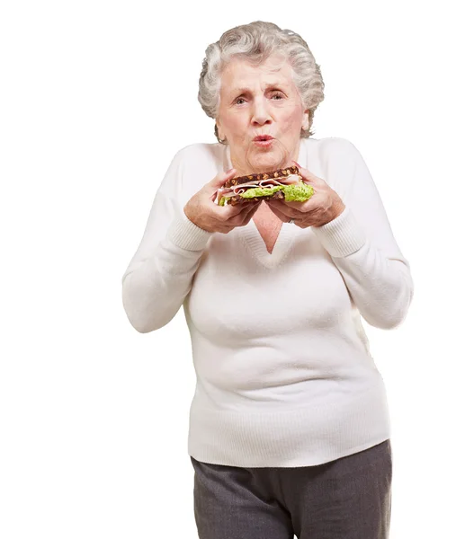 Retrato de mulher idosa segurando um delicioso sanduíche sobre branco — Fotografia de Stock