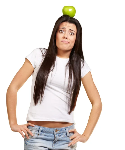Retrato de mujer joven sosteniendo manzana verde en su cabeza sobre whi — Foto de Stock