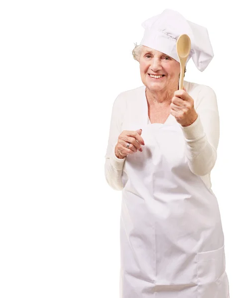 Portret kobiety starszy kucharz trzyma drewnianą łyżką na biały — Zdjęcie stockowe