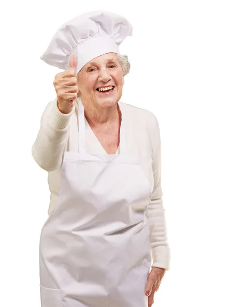 Porträtt av cook senior kvinna gör godkännande gest över vita — Stockfoto