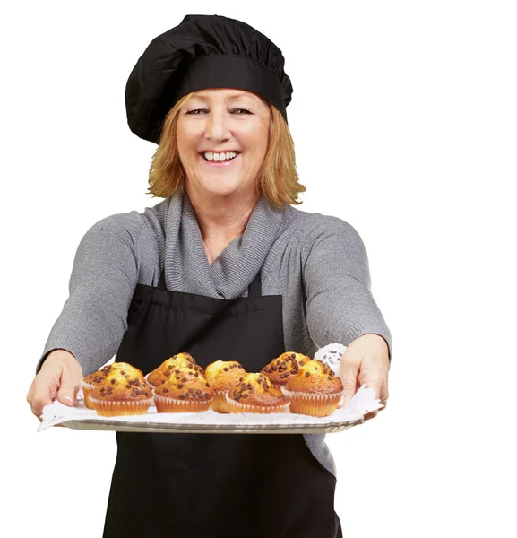 Portret van cook vrouw toont een zelfgemaakte muffins lade over whit — Stockfoto