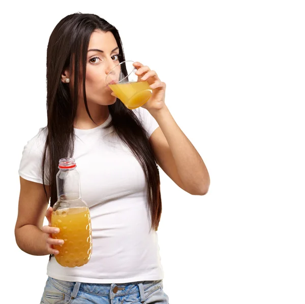 Retrato de una joven bebiendo jugo de naranja contra un bac blanco — Foto de Stock