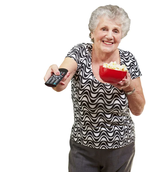Porträt einer glücklichen Seniorin, die den Fernseher über weißem Hintergrund betrachtet — Stockfoto