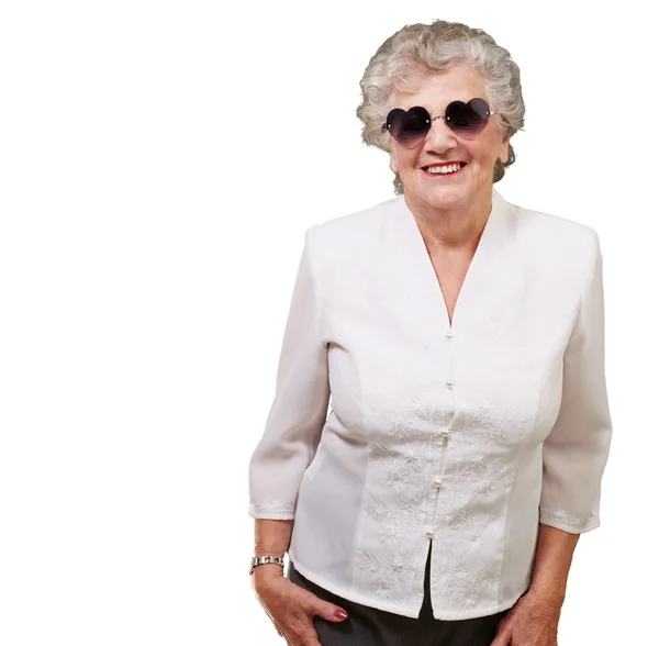 Portrait of happy senior woman wearing heart glasses over white — Stock Photo, Image