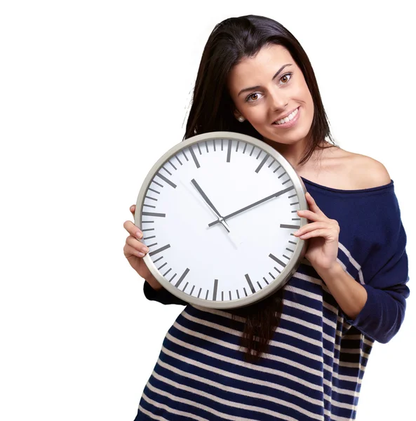 Portrait of young woman holding clock against a white background — Stock Photo, Image