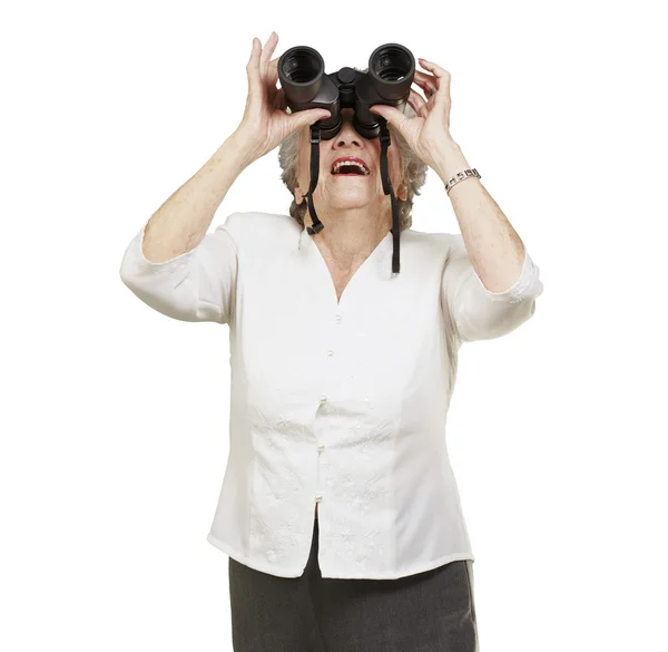 Portret van senior vrouw kijken door een verrekijker tegen een — Stockfoto