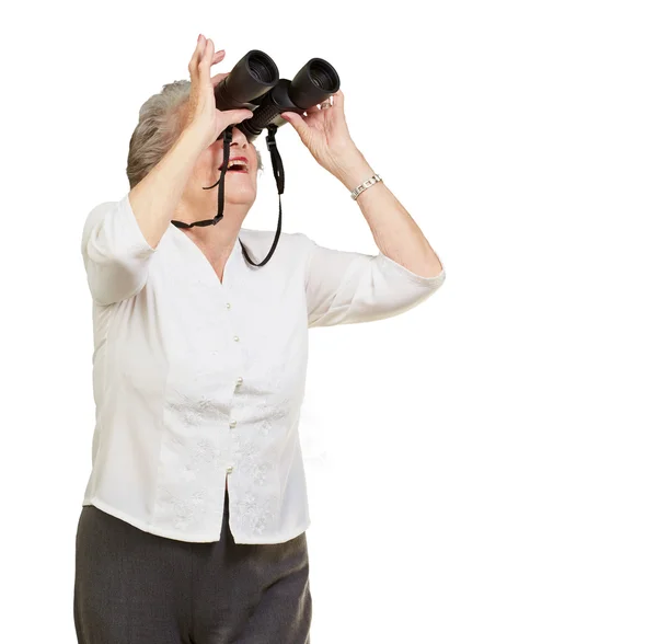 Portrait of senior woman looking through a binoculars over white — Stock Photo, Image