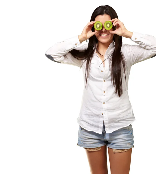 Retrato de una joven sosteniendo rodajas de kiwi delante de sus ojos — Foto de Stock