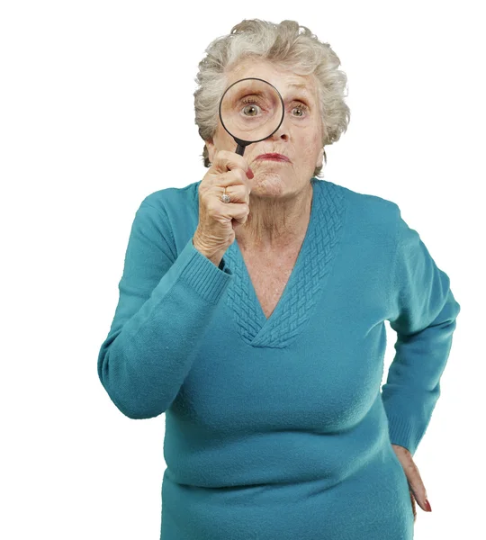 Portrét starší ženy dívat se skrz zvětšovací sklo — Stock fotografie