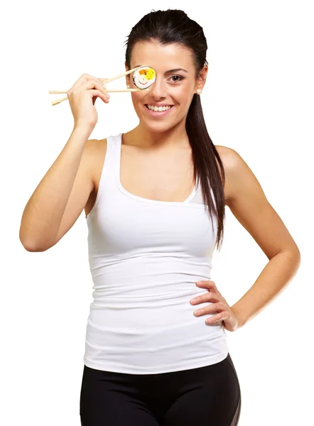 Jeune femme couvrant son oeil avec une pièce de sushi contre un blanc — Photo