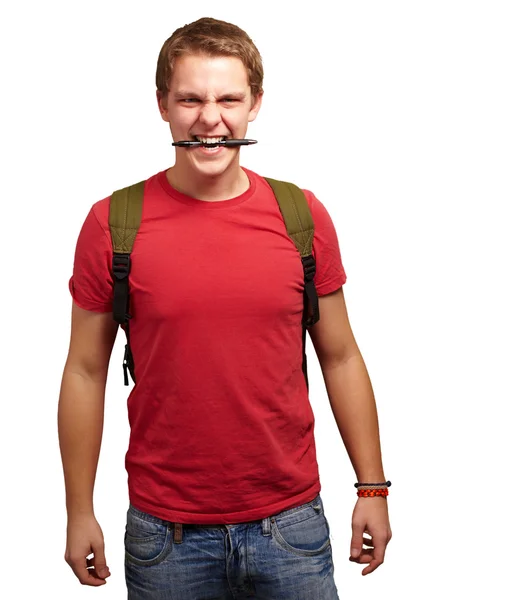 Portret van angry young man bijten pen op witte achtergrond — Stockfoto