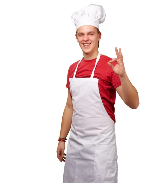 Portrét mladého kuchaře člověka dělá symbolem úspěchu proti bílé — Stock fotografie