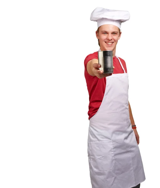 Portrait of young cook man holding a metal tin can over white ba — Stock Photo, Image