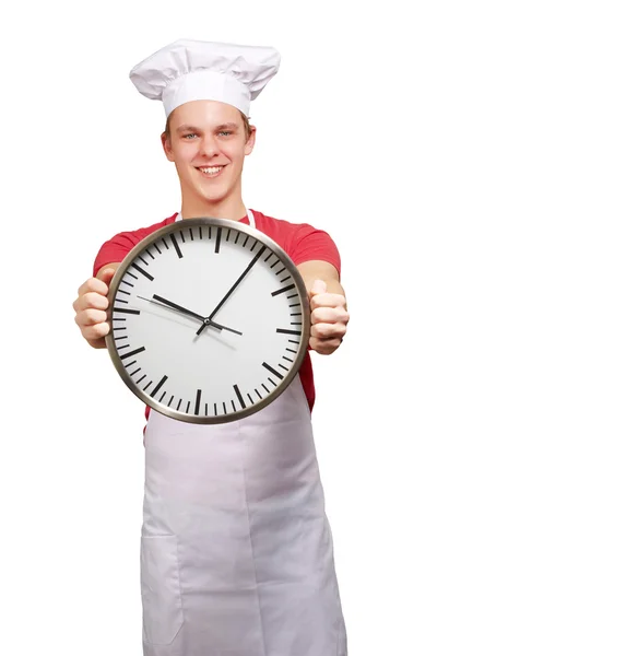 Retrato de jovem cozinheiro segurando relógio sobre fundo branco — Fotografia de Stock